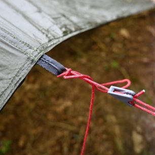 Detail středového oka a reflexní šňůry - WARMPEACE SHELTER TARP