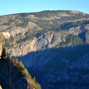 Horolezec při východu slunce kousek od vyhlídky Glacier Point. Yosemite Valley, Kalifornie, USA