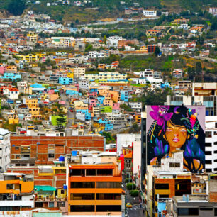 Pestrobarevná zástavba ekvádorských měst se živelně šplhá po svazích And.